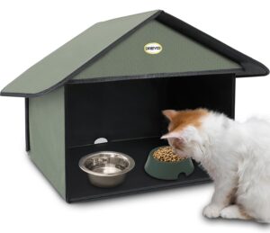 White and orange cat eating at covered feeding station